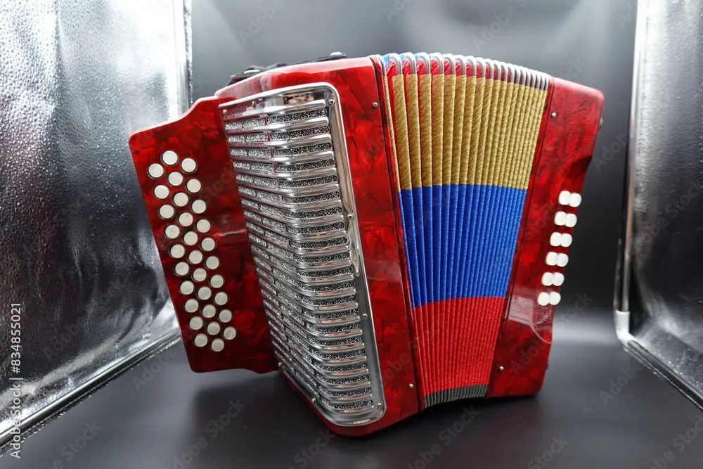 A vibrant red Colombian vallenato accordion featuring the colors of the Colombian flag (red, yellow, and blue). This traditional musical instrument is commonly used in Colombian folk music and is char